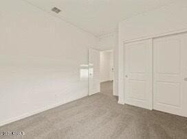 unfurnished bedroom with a closet and carpet