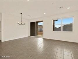 tiled empty room with a notable chandelier