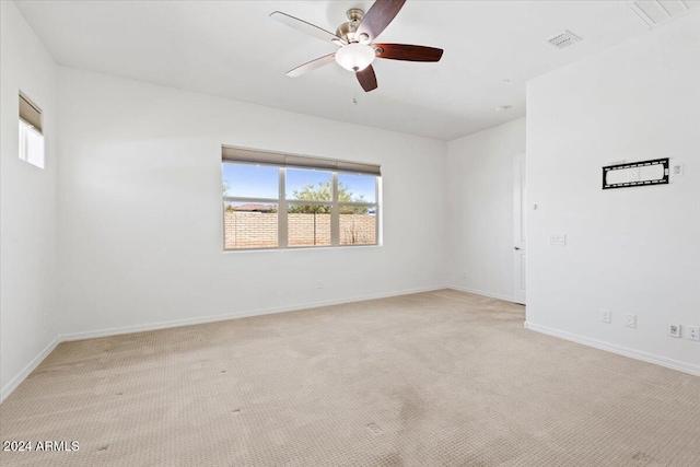 spare room featuring light carpet and ceiling fan