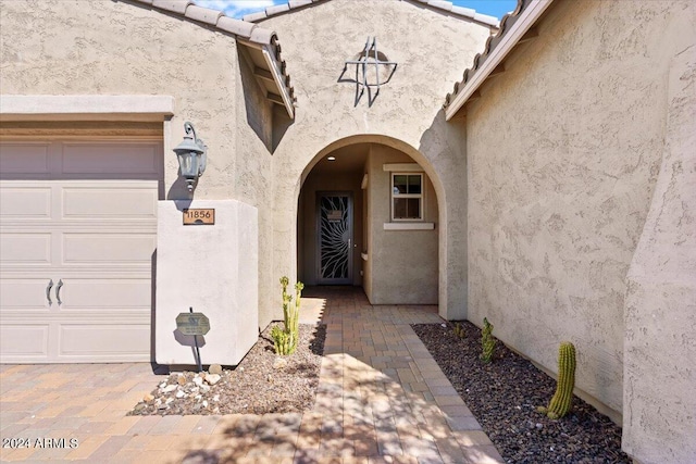 11856 W Lone Tree Trl, Peoria, AZ 85383 - doorway to property featuring stucco siding, a garage, and a tile roof