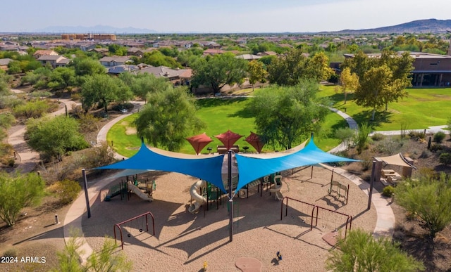 view of swimming pool with a playground, a yard, and a mountain view