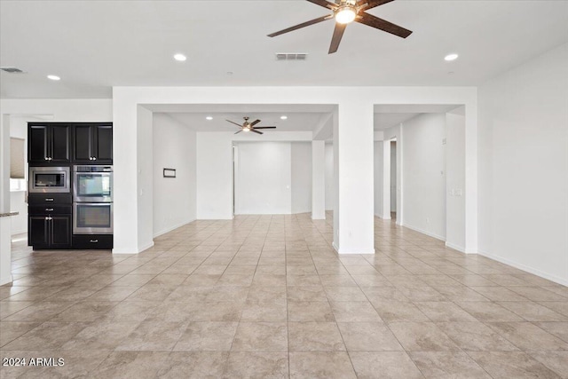 empty room with ceiling fan and light tile patterned flooring