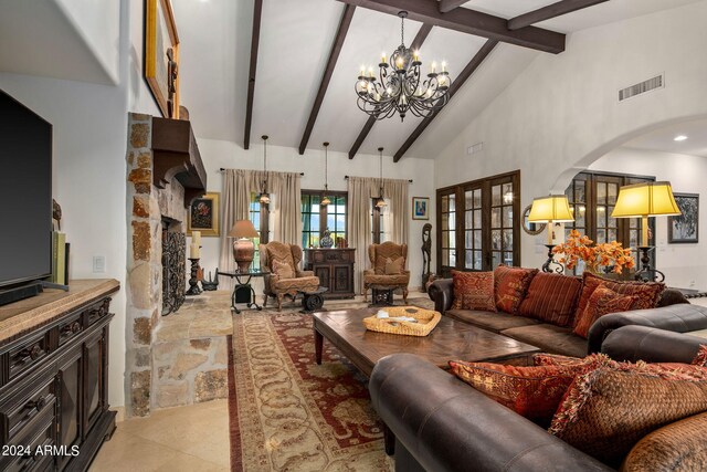 living room with beamed ceiling, a fireplace, high vaulted ceiling, an inviting chandelier, and french doors