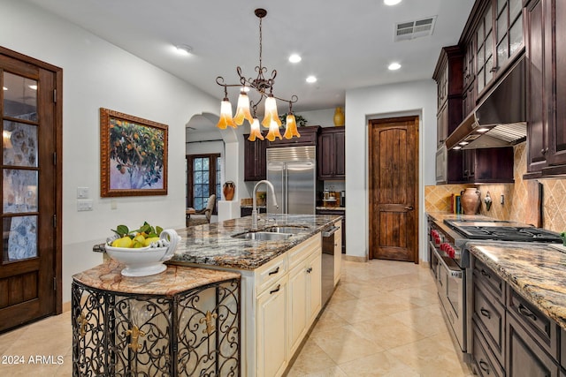 kitchen with premium range hood, sink, high end appliances, a notable chandelier, and decorative backsplash