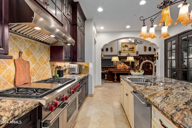 kitchen featuring sink, cream cabinetry, an inviting chandelier, stainless steel appliances, and extractor fan