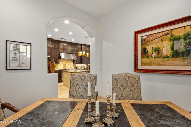 dining space with light hardwood / wood-style floors and a notable chandelier