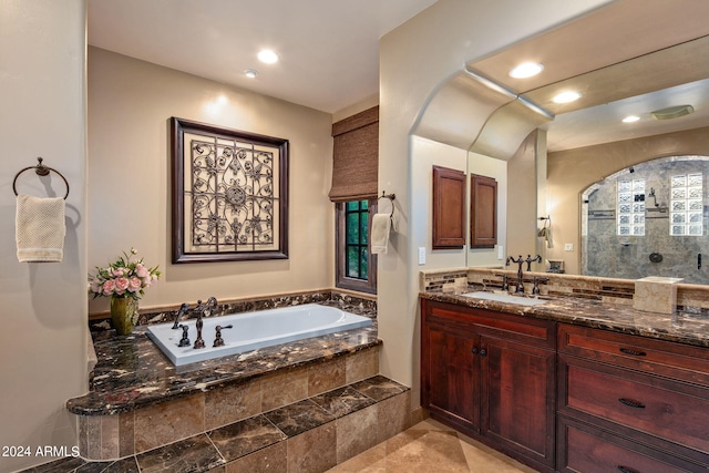 bathroom featuring plus walk in shower, tile patterned flooring, and vanity