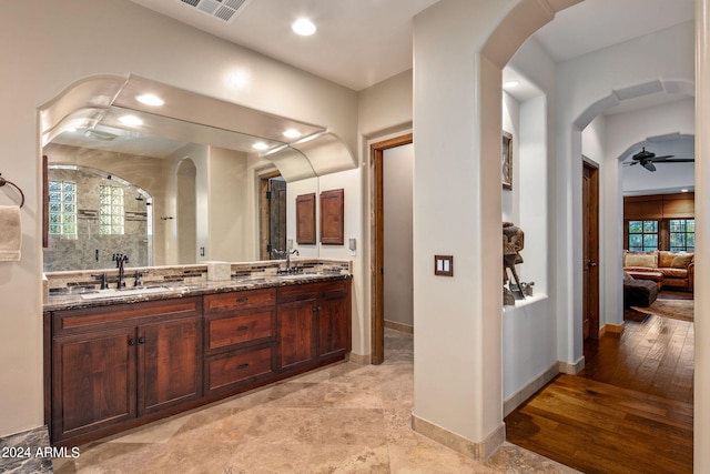 bathroom featuring a shower, vanity, hardwood / wood-style floors, and ceiling fan