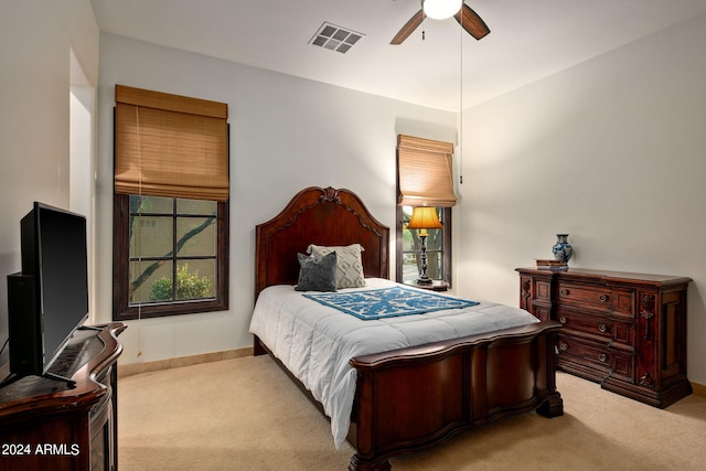 carpeted bedroom with ceiling fan and multiple windows