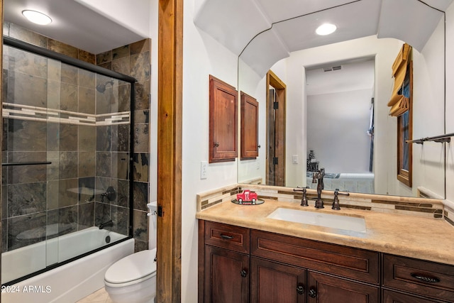 full bathroom with tile patterned floors, bath / shower combo with glass door, vanity, and toilet