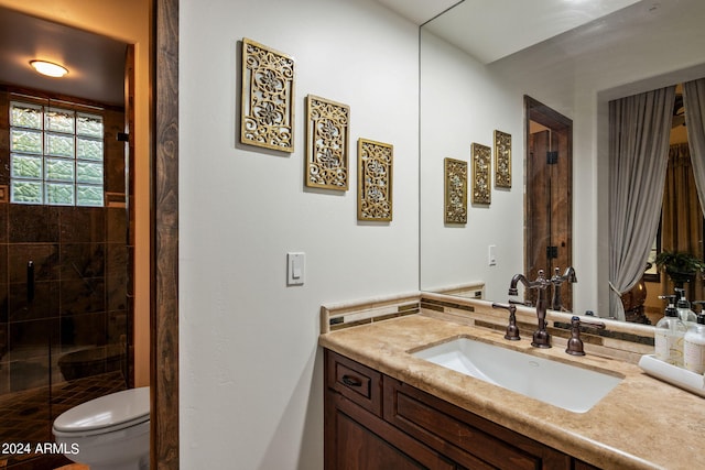 bathroom featuring vanity, toilet, and a shower with door