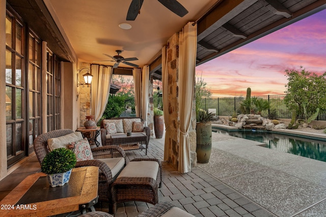 patio terrace at dusk featuring ceiling fan, a fenced in pool, and an outdoor hangout area