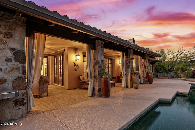 pool at dusk featuring a patio