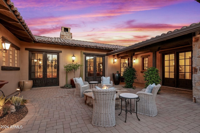 patio terrace at dusk featuring french doors