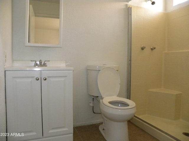 bathroom featuring vanity, tile patterned flooring, toilet, and walk in shower