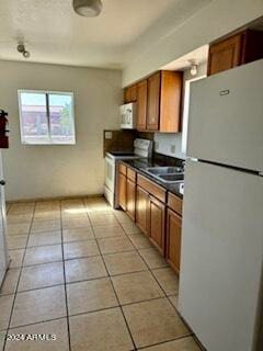 kitchen featuring white appliances, sink, and light tile patterned floors