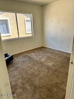 unfurnished room featuring dark carpet