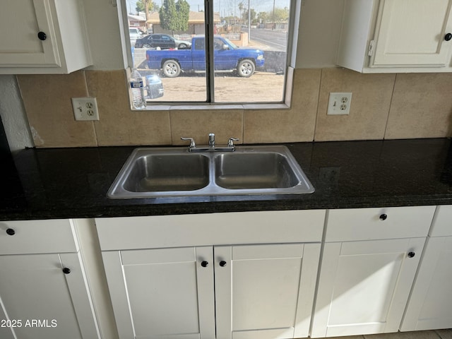 kitchen featuring backsplash, sink, and white cabinets