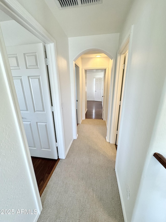2539 N 148th Dr, Goodyear, AZ 85395 - hallway featuring arched walkways, baseboards, and carpet floors