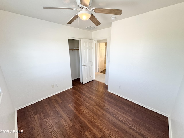 2539 N 148th Dr, Goodyear, AZ 85395 - unfurnished bedroom featuring dark wood finished floors, a closet, baseboards, and ceiling fan