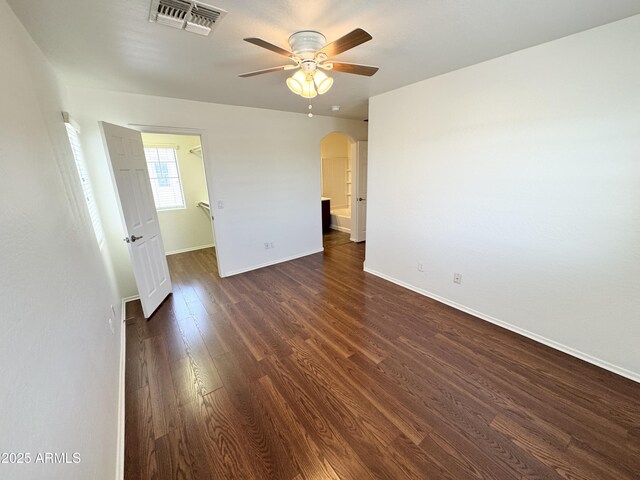 2539 N 148th Dr, Goodyear, AZ 85395 - unfurnished room with arched walkways, ceiling fan, dark wood-style flooring, and baseboards