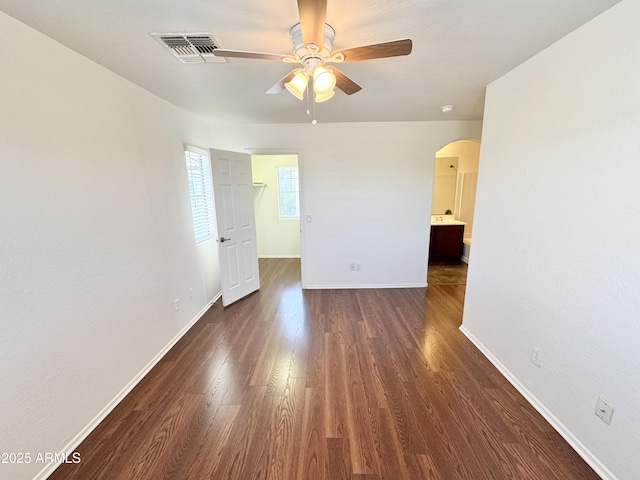2539 N 148th Dr, Goodyear, AZ 85395 - spare room with a ceiling fan, arched walkways, dark wood finished floors, and baseboards