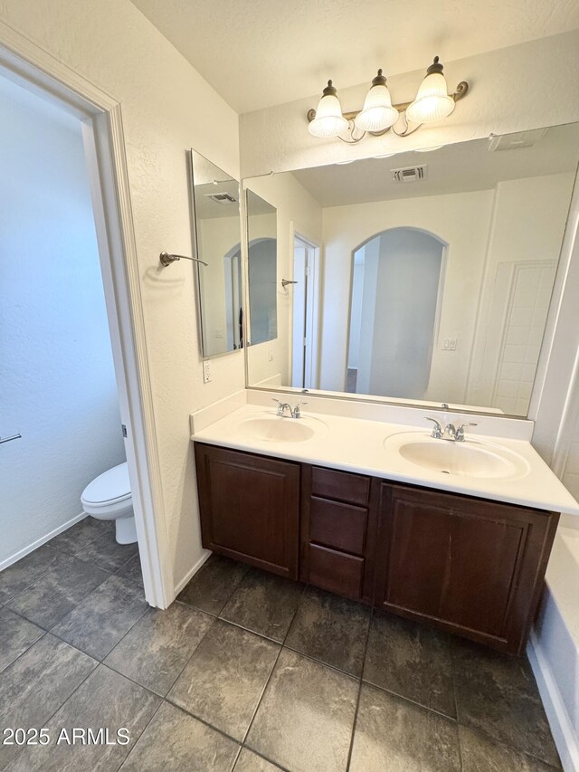 2539 N 148th Dr, Goodyear, AZ 85395 - bathroom featuring double vanity, toilet, and baseboards