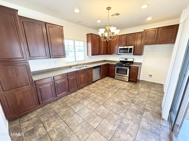 2539 N 148th Dr, Goodyear, AZ 85395 - kitchen with stainless steel appliances, a sink, a chandelier, hanging light fixtures, and recessed lighting
