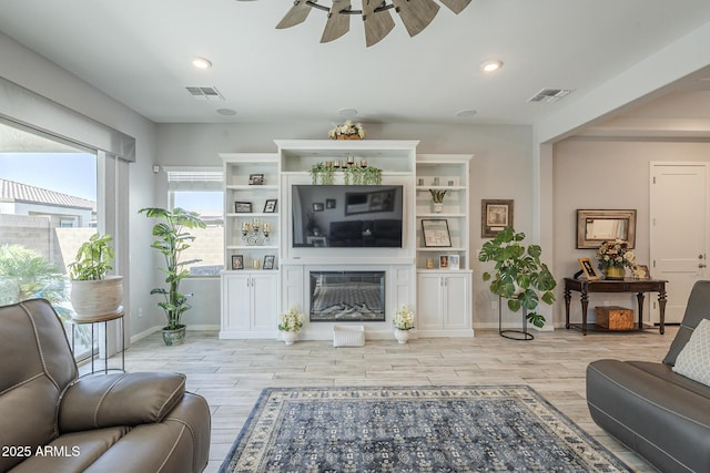 17253 W Echo Ln, Waddell, AZ 85355 - living room featuring ceiling fan, light wood-type flooring, a glass covered fireplace, baseboards, and recessed lighting