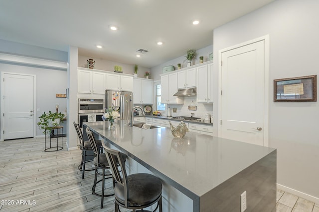 17253 W Echo Ln, Waddell, AZ 85355 - kitchen featuring a sink, stainless steel appliances, white cabinets, light wood-type flooring, and recessed lighting