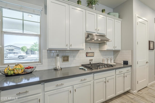 17253 W Echo Ln, Waddell, AZ 85355 - kitchen featuring white cabinets, under cabinet range hood, decorative backsplash, stainless steel gas cooktop, and light wood finished floors