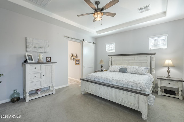 17253 W Echo Ln, Waddell, AZ 85355 - bedroom featuring a barn door, light colored carpet, a raised ceiling, and baseboards