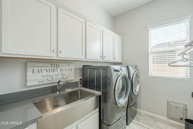 17253 W Echo Ln, Waddell, AZ 85355 - laundry room featuring washing machine and clothes dryer, cabinet space, light wood-style floors, and baseboards