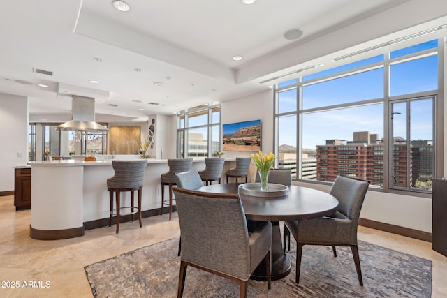dining area featuring baseboards, recessed lighting, and a tray ceiling
