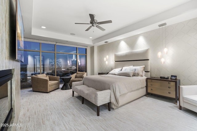 bedroom featuring a tray ceiling, recessed lighting, ceiling fan, and tile walls