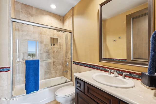 bathroom featuring enclosed tub / shower combo, vanity, and toilet