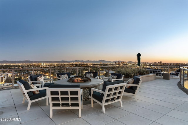 patio terrace at dusk with a fire pit and a mountain view