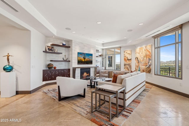 living area featuring a lit fireplace, baseboards, recessed lighting, and light tile patterned floors