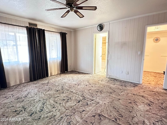 interior space with ceiling fan, a textured ceiling, ensuite bath, and ornamental molding