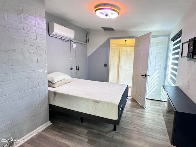 bedroom with dark hardwood / wood-style flooring and a wall mounted air conditioner