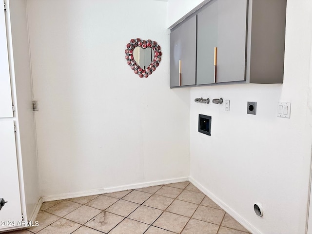 clothes washing area with cabinets, electric dryer hookup, and light tile patterned floors