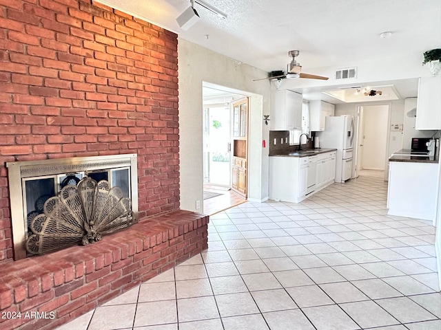 living room with ceiling fan, brick wall, light tile patterned flooring, and sink