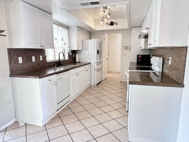 kitchen with white cabinets, a raised ceiling, sink, white appliances, and exhaust hood