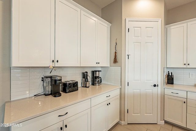 kitchen featuring white cabinetry, backsplash, and light tile patterned floors