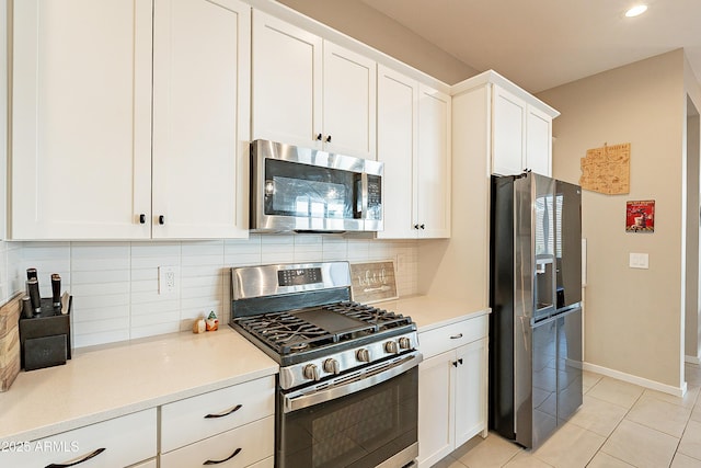 kitchen featuring stainless steel appliances, white cabinets, decorative backsplash, and light tile patterned floors