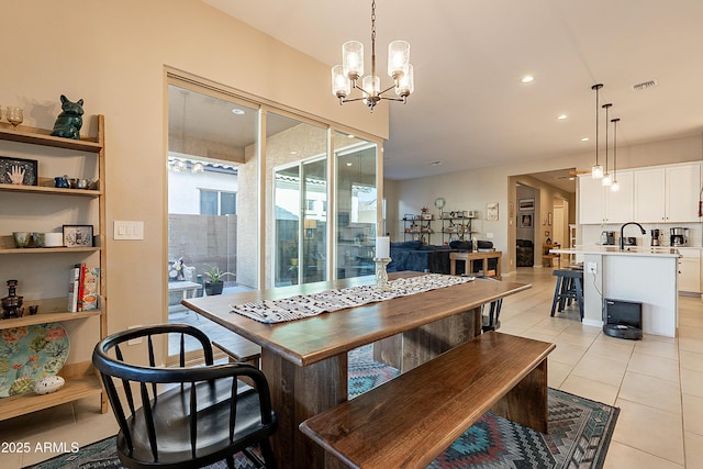 dining room with sink, an inviting chandelier, and light tile patterned floors