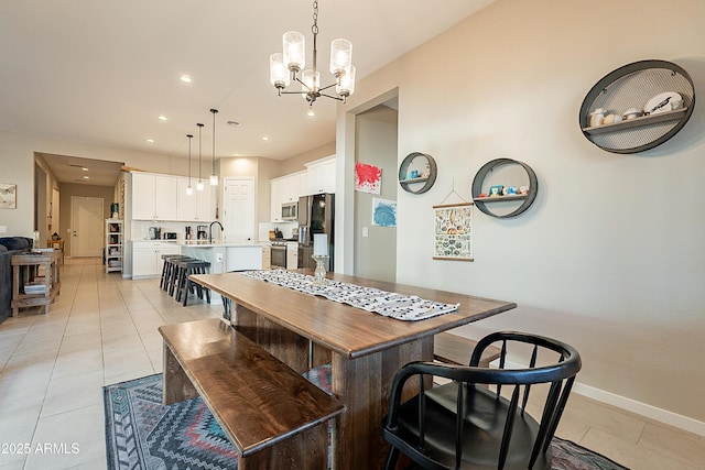 kitchen with stainless steel appliances, decorative light fixtures, white cabinets, a center island, and light tile patterned flooring