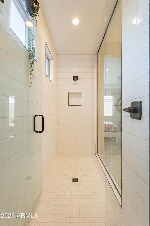 bathroom with a shower with shower door and plenty of natural light