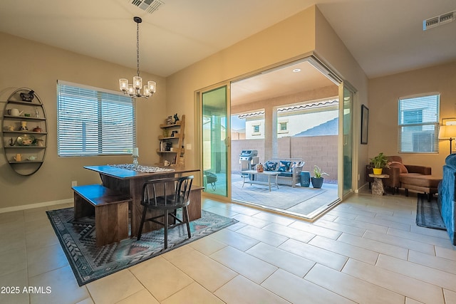 tiled dining area featuring a wealth of natural light and a notable chandelier