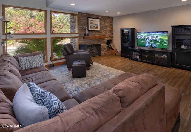 living room with wood-type flooring and a stone fireplace